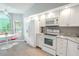 White kitchen with granite countertops and stainless appliances at 1673 Nash Ct, Dunedin, FL 34698