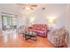 Living room with hardwood floors, red reclining sofa, and access to screened patio at 1673 Nash Ct, Dunedin, FL 34698