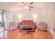 Living room with hardwood floors, red reclining sofa, and access to screened patio at 1673 Nash Ct, Dunedin, FL 34698