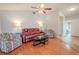 Living room with hardwood floors, red reclining sofa, and access to screened patio at 1673 Nash Ct, Dunedin, FL 34698