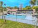 Community pool with patio furniture and lush landscaping at 1673 Nash Ct, Dunedin, FL 34698