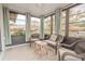 Bright sunroom featuring wicker furniture and window seating at 1673 Nash Ct, Dunedin, FL 34698