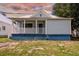 Light blue house with a metal roof, front porch, and small yard at 2314 E 12Th Ave, Tampa, FL 33605