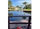 View of calm water with houses and palm trees from a wooden deck at 2571 Cyprus Dr # 1-105, Palm Harbor, FL 34684