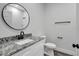 Bathroom with granite vanity and round mirror at 3206 E 38Th Ave, Tampa, FL 33610