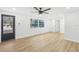 Bright living room featuring light wood floors, a ceiling fan, and large windows at 4215 E Paris St, Tampa, FL 33610