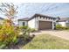 House exterior with landscaping and a paved walkway leading to the garage at 4639 Garofalo Rd, Wesley Chapel, FL 33543