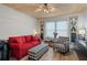 Bright living room with red sofa, plaid chair, and wood flooring at 5220 Brittany S Dr # 201, St Petersburg, FL 33715