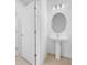 Clean bathroom featuring a pedestal sink and circular mirror at 5913 Laurelcrest Gln, Palmetto, FL 34221