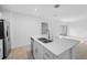 Modern kitchen island with double sink, stainless steel appliances, and white cabinetry at 5913 Laurelcrest Gln, Palmetto, FL 34221