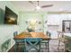 Wooden dining table with teal chairs and ceiling fan at 5914 Fiore Dr, Bradenton, FL 34208