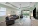 Spacious living room with gray sectional sofa, tile floors, and sliding glass doors leading to patio at 5914 Fiore Dr, Bradenton, FL 34208