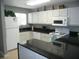 Modern kitchen with white cabinets, black countertops, and stainless steel appliances at 6033 34Th W St # 45, Bradenton, FL 34210