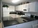 Modern kitchen with white cabinets, black countertops, and stainless steel appliances at 6033 34Th W St # 45, Bradenton, FL 34210