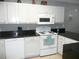White cabinets, black countertops, and a microwave above the stove at 6033 34Th W St # 45, Bradenton, FL 34210