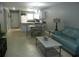 Open living area with teal couch and coffee table, view of kitchen and dining area at 6033 34Th W St # 45, Bradenton, FL 34210