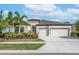 Two-story house with two-car garage, landscaping, and palm trees at 6442 Maiden Sea Dr, Apollo Beach, FL 33572