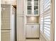 White kitchen with glass-front cabinets and mosaic backsplash at 744 Cadiz Rd # 1, Venice, FL 34285