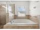 Relaxing bathtub with tile surround and window offering natural light at 8123 Rothbury Hills Pl, Gibsonton, FL 33534