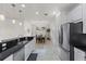 Modern kitchen with breakfast bar and view into dining area at 8424 Alberata Vista Dr, Tampa, FL 33647