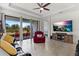 Comfortable living room featuring a large TV, red recliner, and access to a patio at 8424 Alberata Vista Dr, Tampa, FL 33647