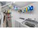 Functional laundry room with a washer, dryer, wire shelving, and storage for cleaning supplies at 960 Starkey Rd # 7103, Largo, FL 33771