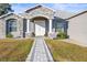 Close-up of the front entrance with decorative columns and attractive landscaping at 10920 Flint Estates Dr, Thonotosassa, FL 33592