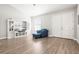Bright living room featuring wood floors, custom shelving, and a comfortable blue armchair at 10920 Flint Estates Dr, Thonotosassa, FL 33592