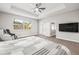 Bright main bedroom with a ceiling fan, backyard views, and an entertainment center at 10920 Flint Estates Dr, Thonotosassa, FL 33592