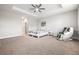 Spacious main bedroom featuring plush carpeting, tray ceiling, and a modern massage chair at 10920 Flint Estates Dr, Thonotosassa, FL 33592