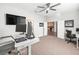 Well-lit office with modern desk setup, ceiling fan, and carpeted floor at 10920 Flint Estates Dr, Thonotosassa, FL 33592