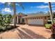 Brick paver driveway and walkway leading to a tan house with white garage door at 1108 92Nd Nw St, Bradenton, FL 34209