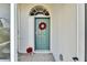 Green front door with wreath and poinsettia plant at 11225 Scotchwood Dr, Riverview, FL 33579