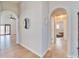 Bright hallway with wood floors and arched doorways at 11225 Scotchwood Dr, Riverview, FL 33579