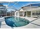 Spacious screened-in pool area with patio furniture and a waterfall feature at 11225 Scotchwood Dr, Riverview, FL 33579