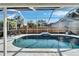 Relaxing screened-in pool with tiled accents and waterfall feature at 11225 Scotchwood Dr, Riverview, FL 33579