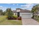 Single-story home with tile roof, landscaping, and a two-car garage at 11465 Bitola Dr, Odessa, FL 33556