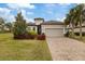 One-story house with a two-car garage, paver driveway, and lush landscaping at 11465 Bitola Dr, Odessa, FL 33556
