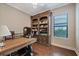 Home office with built-in bookshelves and hardwood floors at 11465 Bitola Dr, Odessa, FL 33556