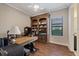 Home office with built-in bookshelves and hardwood floors at 11465 Bitola Dr, Odessa, FL 33556