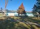Cute light blue home with palm trees and a well-manicured lawn at 1279 Dinnerbell E Ln, Dunedin, FL 34698