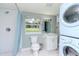 Updated bathroom with white tile shower, toilet, and stackable washer/dryer at 1341 Springdale St, Clearwater, FL 33755