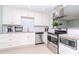Modern kitchen with white cabinets, granite counters, and stainless steel appliances at 1341 Springdale St, Clearwater, FL 33755