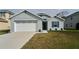 Gray house with white garage door, landscaping, and walkway at 15415 Trinity Fall Way, Bradenton, FL 34212