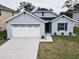 Gray house with white garage door, landscaping, and walkway at 15415 Trinity Fall Way, Bradenton, FL 34212