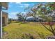 Landscaped backyard with lush greenery and neighboring homes at 1608 Sunset Wind Loop, Oldsmar, FL 34677