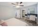 Comfortable bedroom with a built-in workspace and ceiling fan at 1608 Sunset Wind Loop, Oldsmar, FL 34677