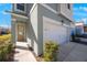 Townhome entryway with light beige door and white garage at 1608 Sunset Wind Loop, Oldsmar, FL 34677