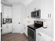 Modern kitchen with white cabinets, stainless steel appliances, and ample counter space at 1608 Sunset Wind Loop, Oldsmar, FL 34677