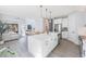 Open concept kitchen with white island, stainless steel appliances, and view to living room at 1608 Sunset Wind Loop, Oldsmar, FL 34677